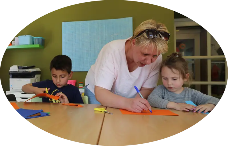 Teacher Helping Kids in Classroom